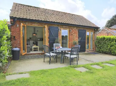 a patio with a table and chairs in front of a house at 1 Bed in Saxmundham oc-stab in Friston