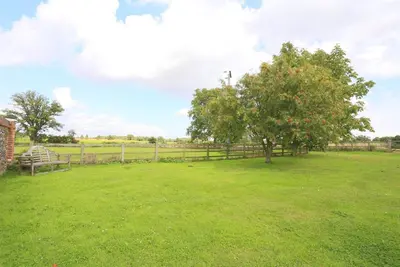 a field with a fence and a tree in the grass at 1 Bed in Saxmundham oc-stab in Friston