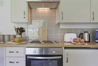 a kitchen with white cabinets and a stove top oven at 1 Bed in Saxmundham oc-stab in Friston
