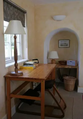 a wooden desk with a lamp on top of it at The Old Post Office, Hilton in Huntingdon