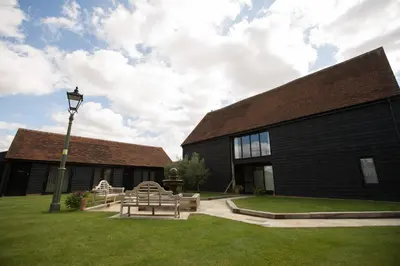 a building with benches and a street light in the grass at Channels Retreat in Chelmsford