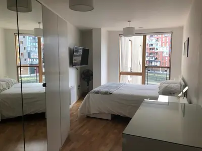 a bedroom with two beds and a mirror at Toothbrush Apartments - Ipswich Waterfront - Quayside in Ipswich