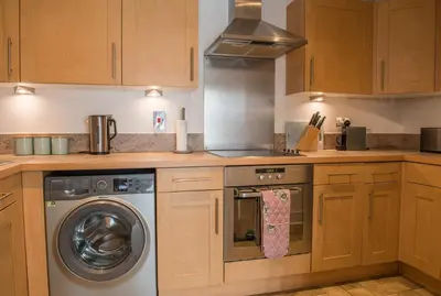 a kitchen with a washing machine and a stove at Toothbrush Apartments - Ipswich Waterfront - Anchor St in Ipswich