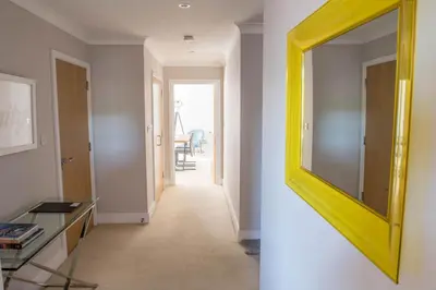 a hallway with a yellow mirror in a room at Toothbrush Apartments - Ipswich Waterfront - Anchor St in Ipswich