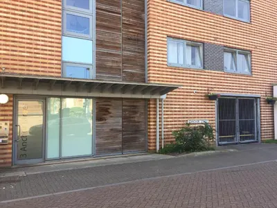 a brick building with a glass door on a street at Toothbrush Apartments - Ipswich Waterfront - Anchor St in Ipswich