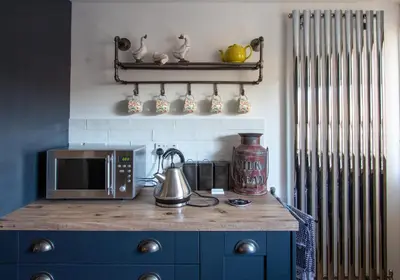 a kitchen with a counter with a microwave and a stove at Stylish Town Centre House with Garden and Parking Opposite in Bury Saint Edmunds
