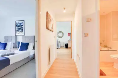 a bedroom with a bed and a bathroom at Niche Parkview Apartments in Brentwood