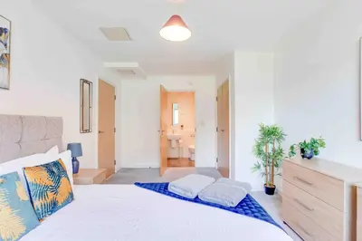 a bedroom with a large white bed with two pillows at Niche Parkview Apartments in Brentwood