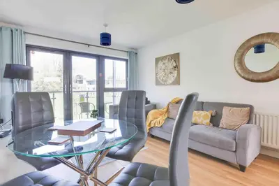 a living room with a glass table and a couch at Niche Parkview Apartments in Brentwood