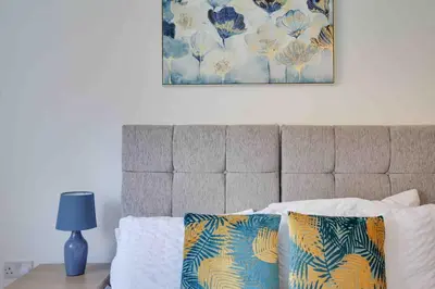 a bed with two pillows and a picture on the wall at Niche Parkview Apartments in Brentwood