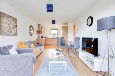 a living room with a couch and a tv at Niche Parkview Apartments in Brentwood