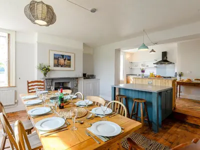 a dining room with a table and a kitchen at Colveston Manor in Cranwich