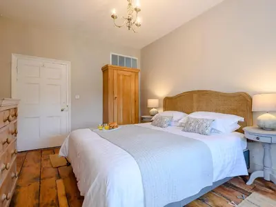 a bedroom with a large white bed with a chandelier at Colveston Manor in Cranwich