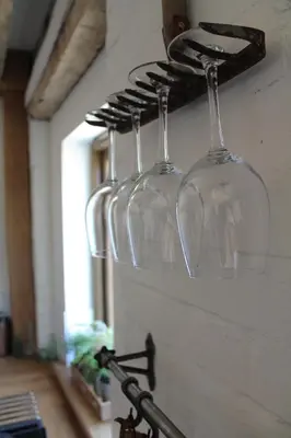 three wine glasses are hanging on a wall at The Dovecote - unique self-contained 1bed renovated barn in Saffron Walden