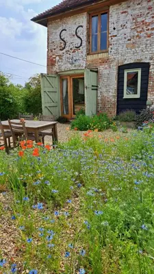 a building with a bunch of flowers in front of it at The Dovecote - unique self-contained 1bed renovated barn in Saffron Walden