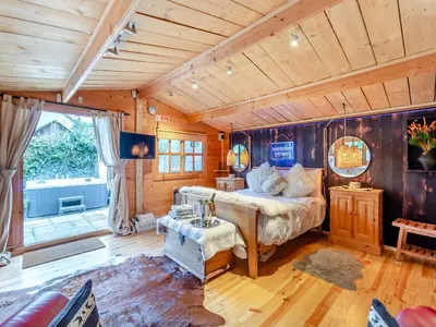 a bedroom with a bed in a room with wooden walls at Easthorpe Retreat in Copford