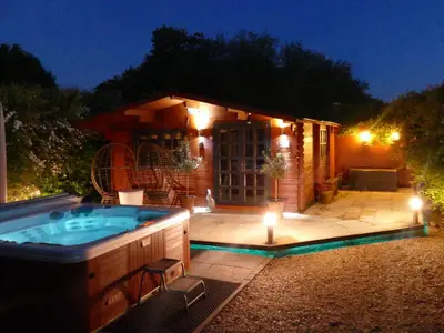 a hot tub in a backyard at night with lights at Easthorpe Retreat in Copford