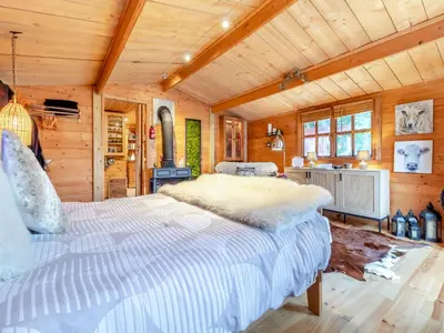 a bedroom with a large bed in a wooden room at Easthorpe Retreat in Copford