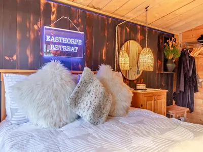 a bed with white pillows and a sign on it at Easthorpe Retreat in Copford