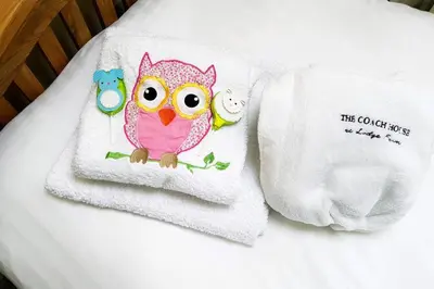 a towel with an owl and two birds on it at The Coach House at Lodge Farm with Hot Tub in Hilgay
