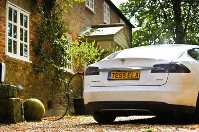 a white car parked in front of a house at The Coach House at Lodge Farm with Hot Tub in Hilgay