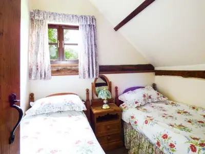 a bedroom with two twin beds and a window at The Granary in Norwich
