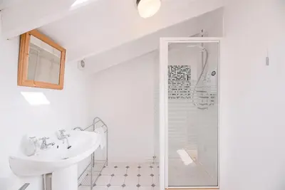 a white bathroom with a sink and a shower at The Shealing, Waldringfield in Waldringfield