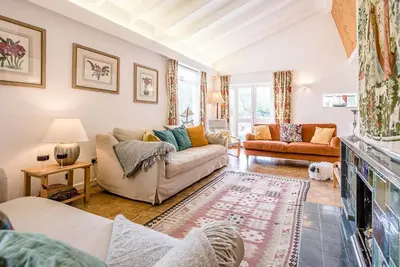 a living room with a couch and a fireplace at The Shealing, Waldringfield in Waldringfield
