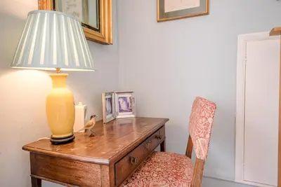a table with a lamp on top of it with a chair at The Shealing, Waldringfield in Waldringfield