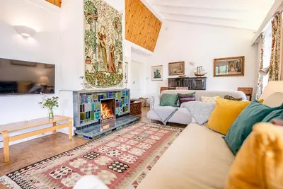 a living room with a couch and a fireplace at The Shealing, Waldringfield in Waldringfield