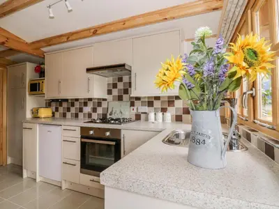 a kitchen with a vase of flowers on a counter at Someplace Else in Diss