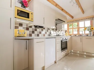 a kitchen with white cabinets and a yellow microwave at Someplace Else in Diss