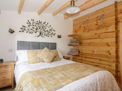a bedroom with a bed and a wooden wall at Someplace Else in Diss