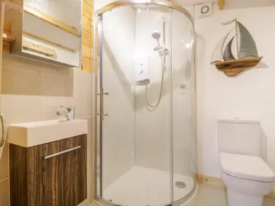 a bathroom with a shower and a toilet and a sink at Someplace Else in Diss