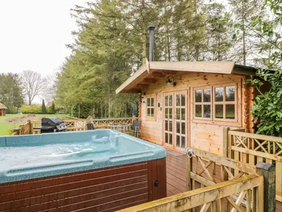 a large hot tub next to a wooden house at Someplace Else in Diss