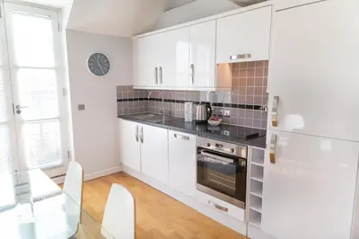 a kitchen with white cabinets and a stove at Citystay Living - Marino Place in Cambridge
