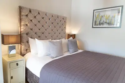 a bedroom with a large bed with a purple bedspread at Citystay Living - Marino Place in Cambridge