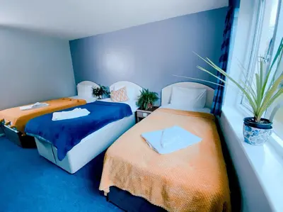 two beds sitting next to each other in a room at Redwings Lodge Baldock in Baldock
