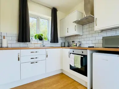 a white kitchen with white cabinets and a window at Fox Lodge - Uk30605 in Pidley