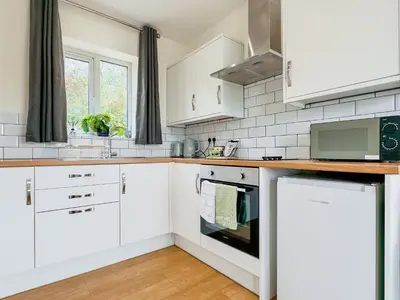 a white kitchen with white cabinets and a window at Hare Lodge - Uk30604 in Pidley