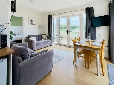 a living room with a table and a dining room at Badger Lodge - Uk30603 in Pidley