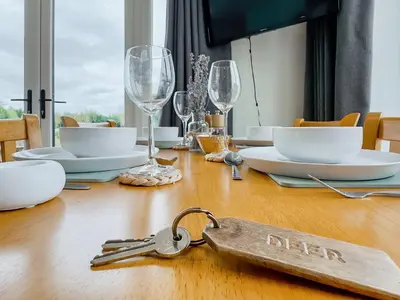 a table with a pair of keys on a wooden table at Badger Lodge - Uk30603 in Pidley