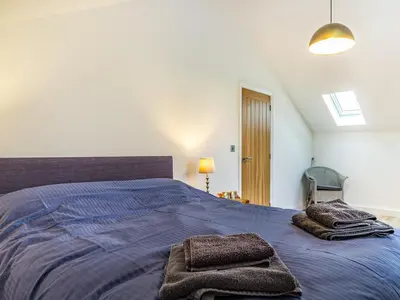 a bedroom with a large bed with towels on it at Fenside Way in Wicken