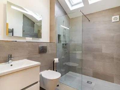 a bathroom with a shower and a toilet and a sink at Fenside Way in Wicken