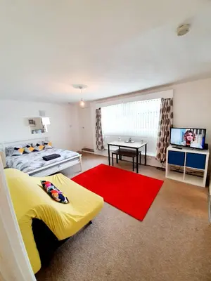 a bedroom with a yellow bed and a red rug at Rayleigh Town Centre 2 Bedroom Apartment in Rayleigh
