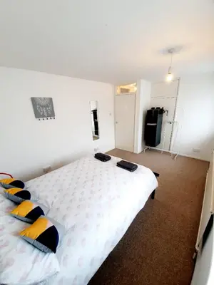 a bedroom with a large white bed with pillows at Rayleigh Town Centre 2 Bedroom Apartment in Rayleigh
