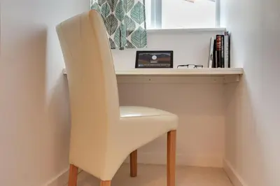 a white chair sitting in front of a desk at Modern Spacious Apartments in Bishops Stortford
