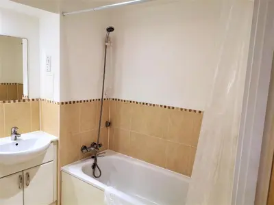 a bathroom with a bath tub and a sink at Modern Spacious Apartments in Bishops Stortford