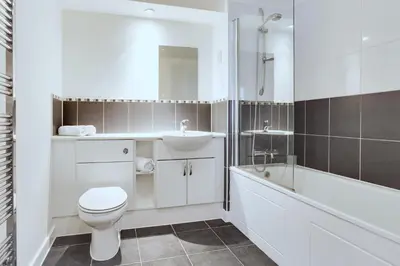a bathroom with a white toilet and a sink and a tub at Modern Spacious Apartments in Bishops Stortford