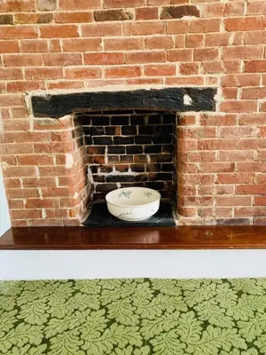 a brick fireplace with a bowl on top of it at Ye Olde White Harte Hotel in Burnham on Crouch